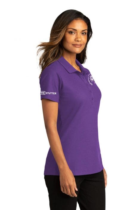 A woman with medium skin tone wearing a purple polo shirt that reads "we stutter" on the left side, standing confidently with her hands slightly on her hips, isolated on a white background, holding an NSA Golf Towel.