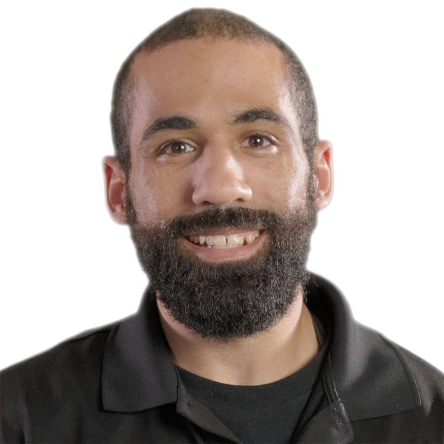 Marvin Wiley, a man with a medium-length black beard and short hair, is smiling at the camera. He is wearing a dark-colored polo shirt against a plain white background.