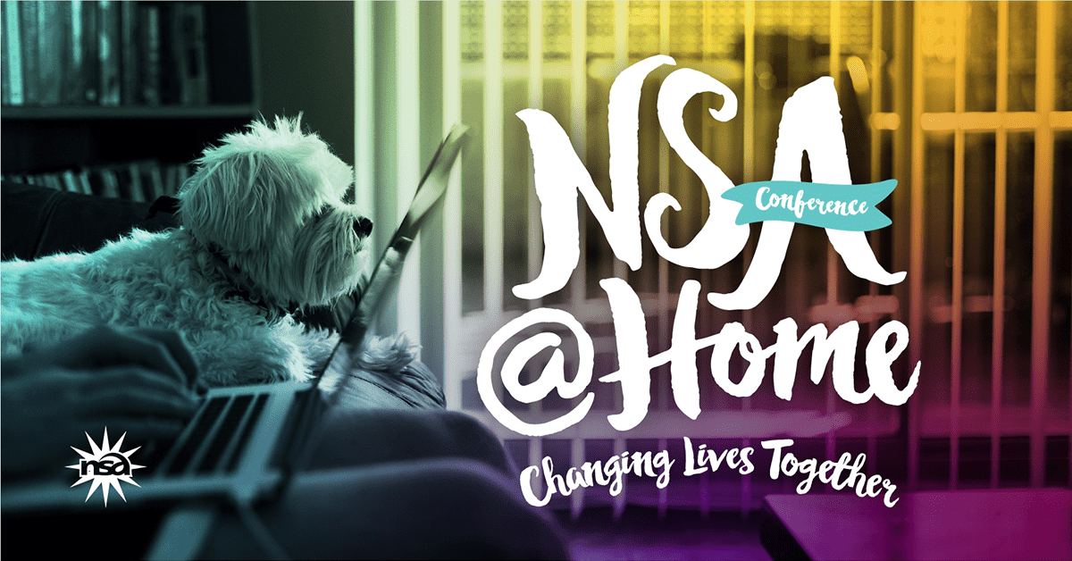 A white dog sitting on a couch looks at a laptop screen displaying the logo "41st Annual NSA Conference @ home - changing lives together" with a colorful background.