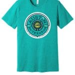A teal Annual Conference 3/4 T-Shirt with a graphic print featuring a circular design that reads "austin, texas" around a logo stating "all in, all together, nfa national 2021.